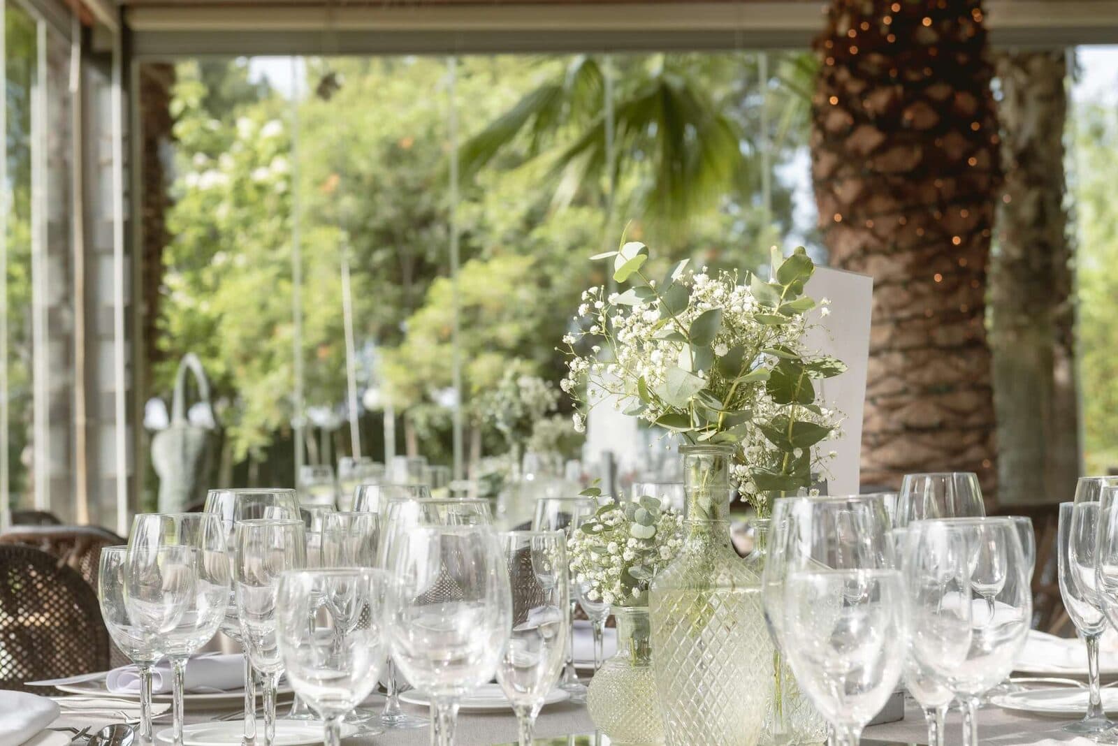 Detalle de mesa de boda con cristalería y flores blancas en la Finca Sansui