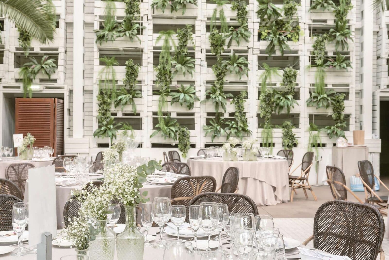 Banquete de boda montado en Finca Sansui, con mesas vestidas, cristalería y jardines verticales
