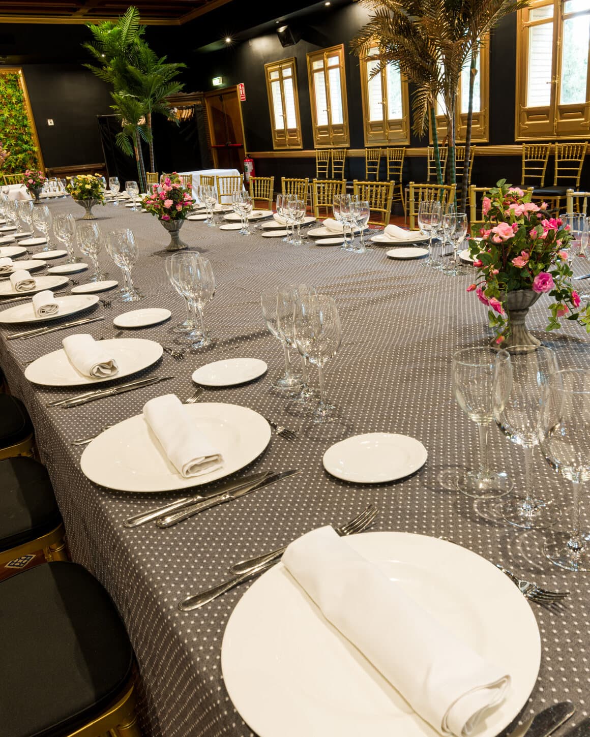 Mesa de banquete montada por Eventos El Cachirulo con sillas doradas y cristalería en un salón cálido